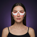 Studio portrait of a woman wearing the Ophelix Beauty LumiEye™ eye care device, featuring a sleek white design with a soft red LED glow around the under-eye area, set against a deep purple background.